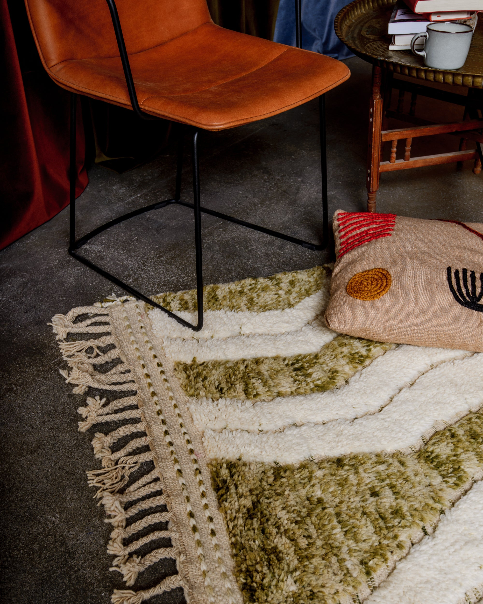 Modern Berber rug on floor beside a vintage green child's bed.