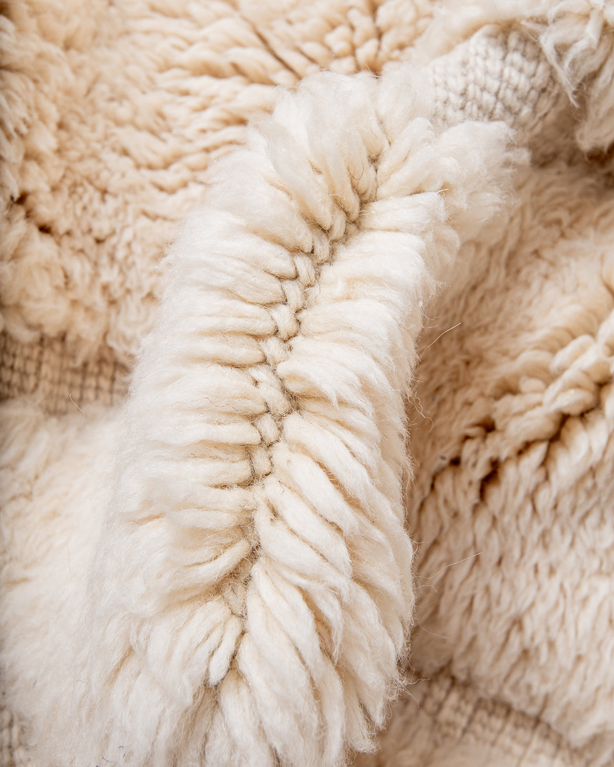 Close up of thick wool of cream Beni M'rirt rug. 