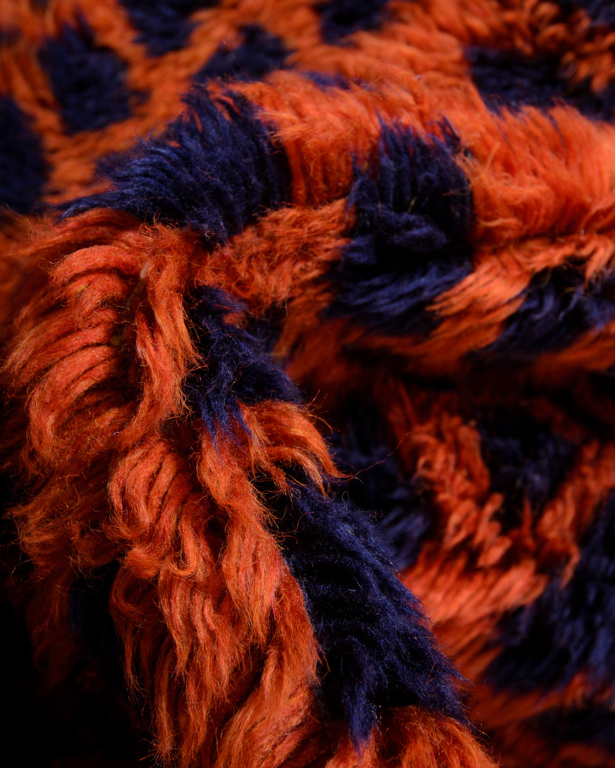 Detail of fluffy navy blue and contrasting rust red wool of Beni M'rirt rug.