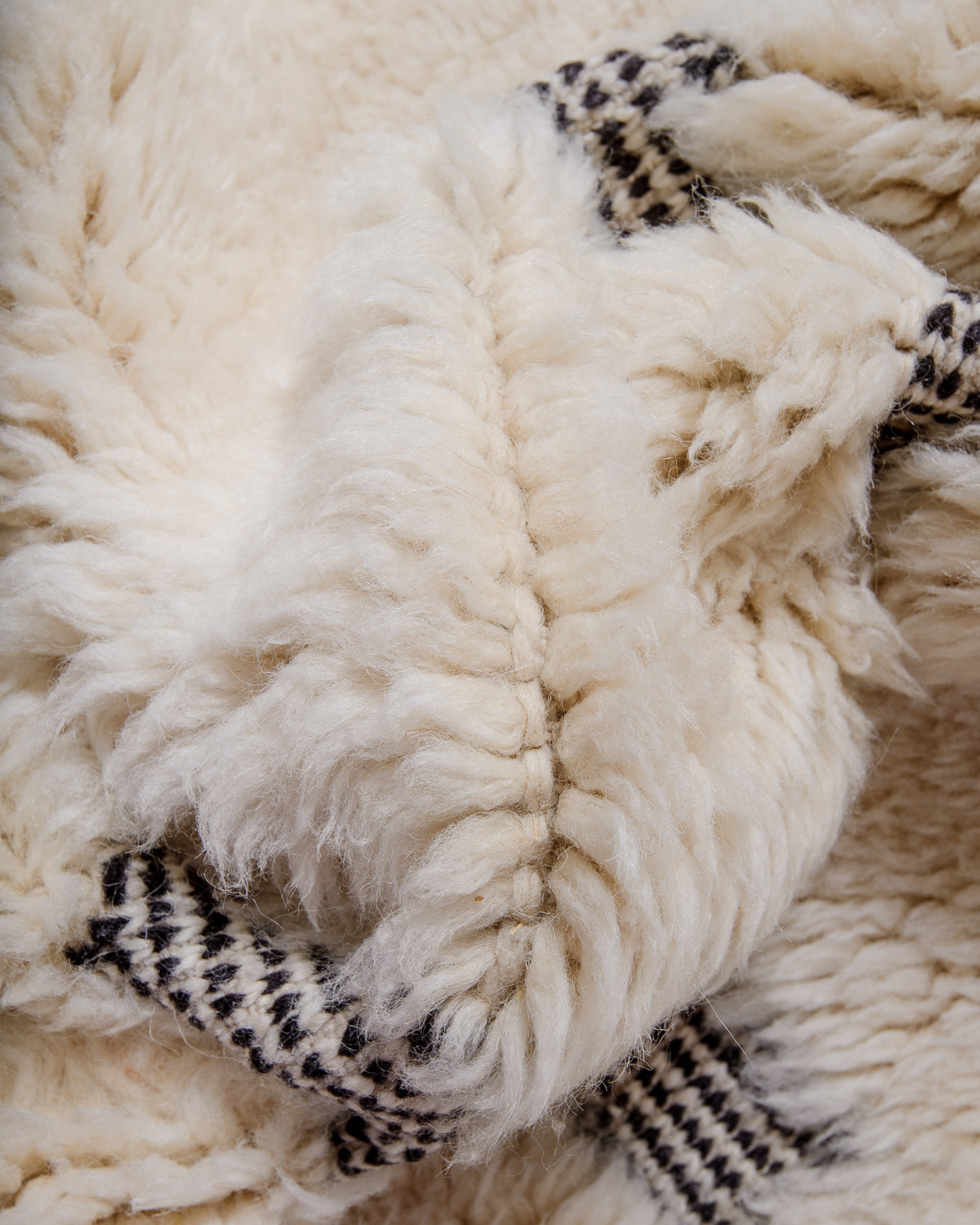 Knotted cream wool on a Beni M'rirt rug with  black and white design.