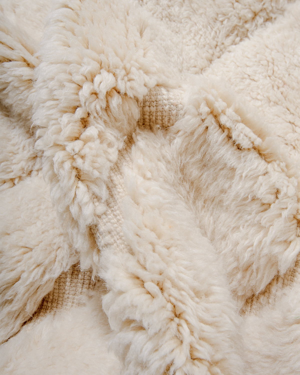 Detail of fluffy Beni M'rirt rug in cream wool.