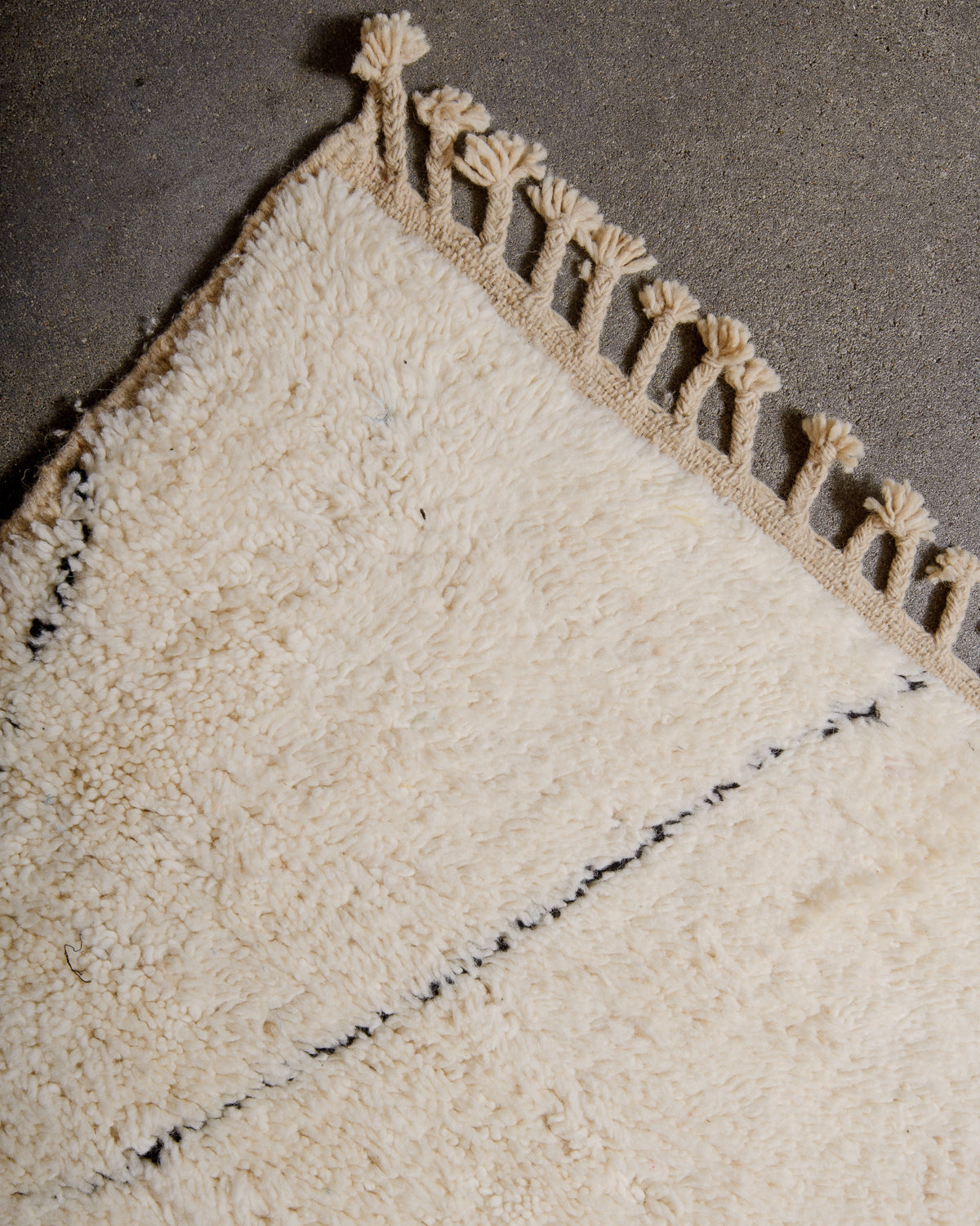 Natural wool tassels on edge of Beniourain rug.