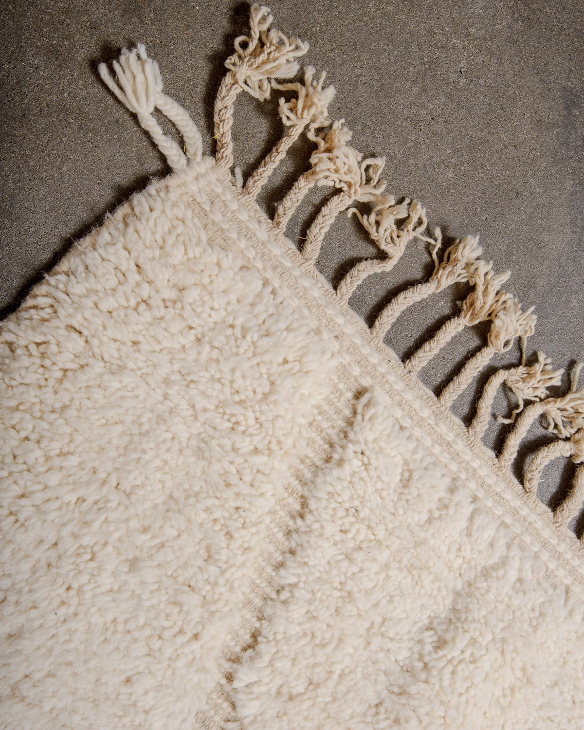 Natural wool tassels on a Berberlin Beniourain Rug made of natural cream wool with tightly woven ends.