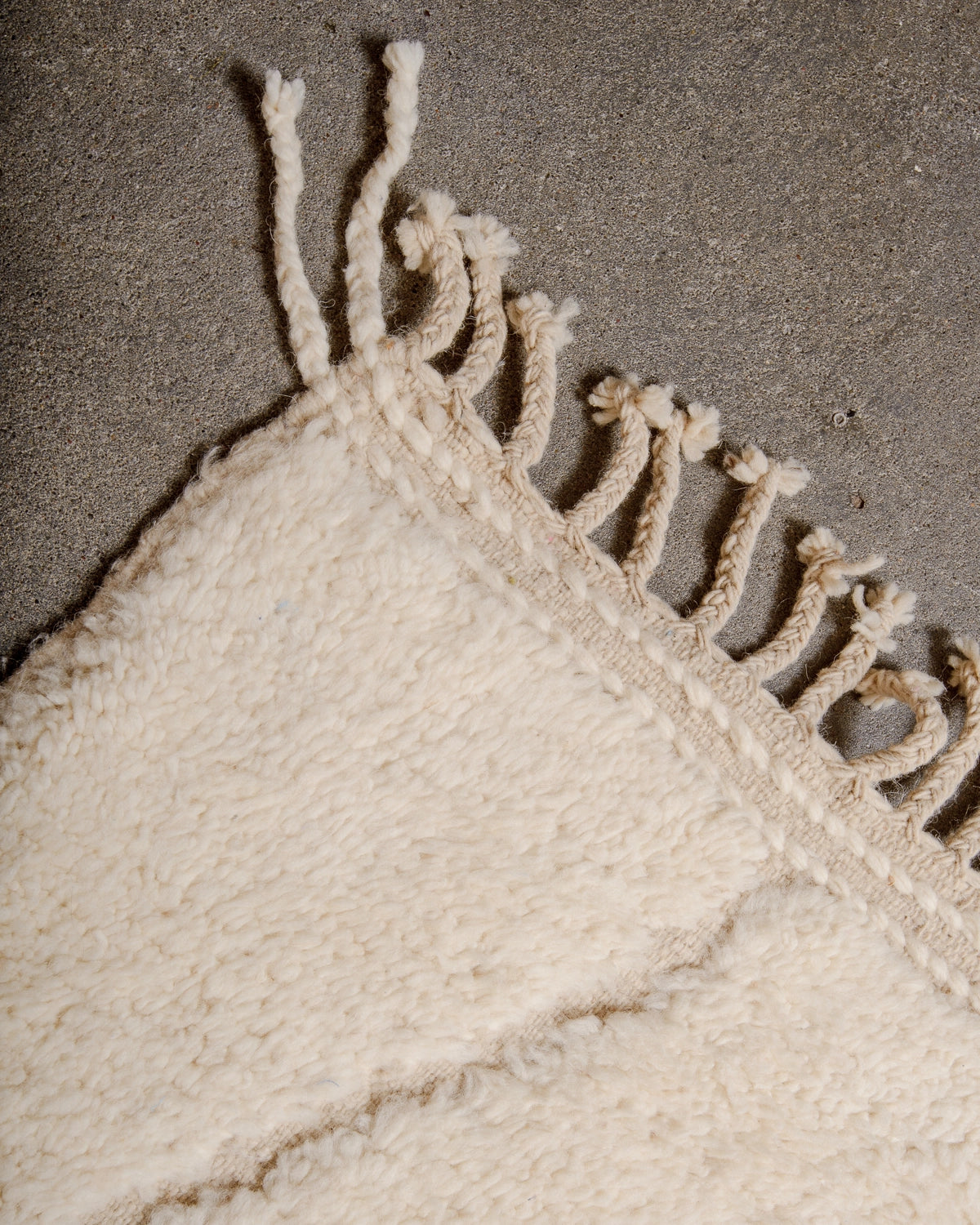 Natural wool tassels on a Berberlin Beniourain Rug made of natural cream wool with tightly woven ends.