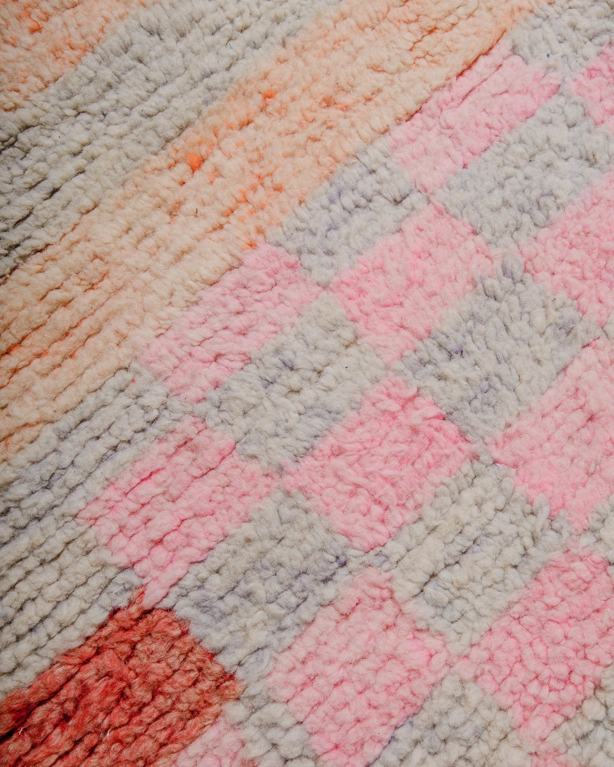 Detail of Berberlin Vintage Berber Rug made of fluffy wool in pink, apricot and lavender.