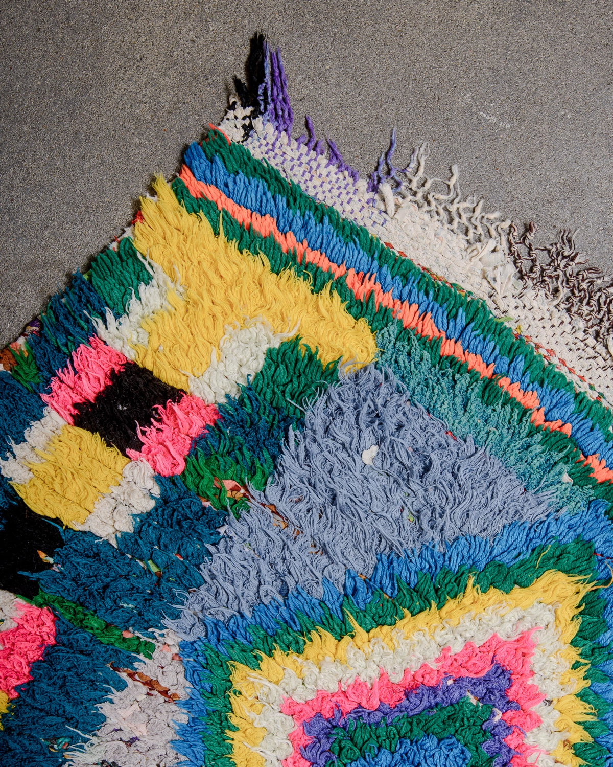 Detail of Berberlin Vintage Berber Rug in shades of red, cream, grey and blue with coloured diamond motifs in the center.