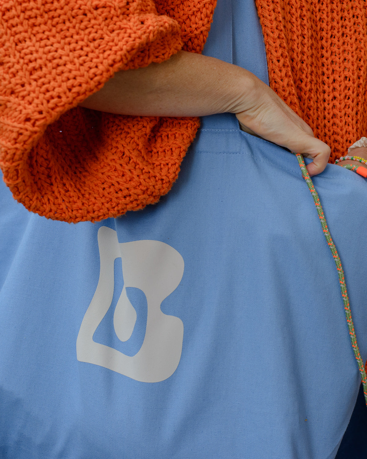 Blue canvas tote bag with Berberlin logo in orange and white.