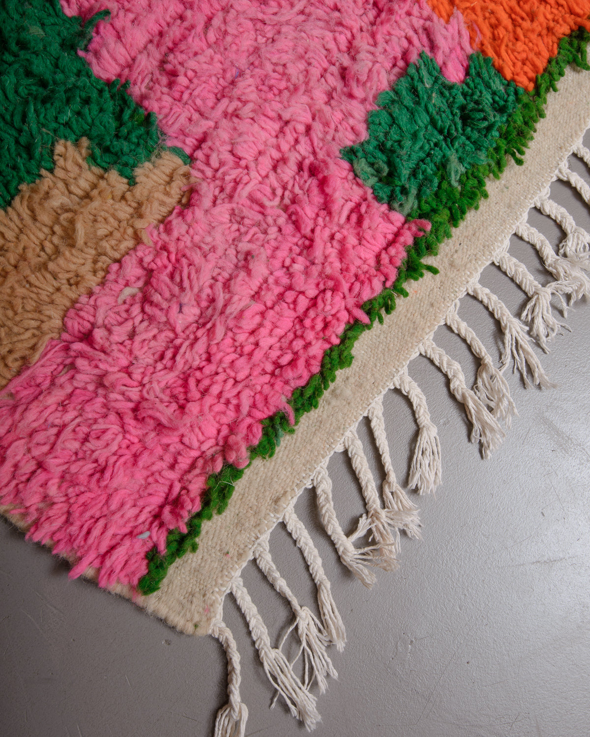 Corner of Berberlin azilal rug with white cotton tassels.