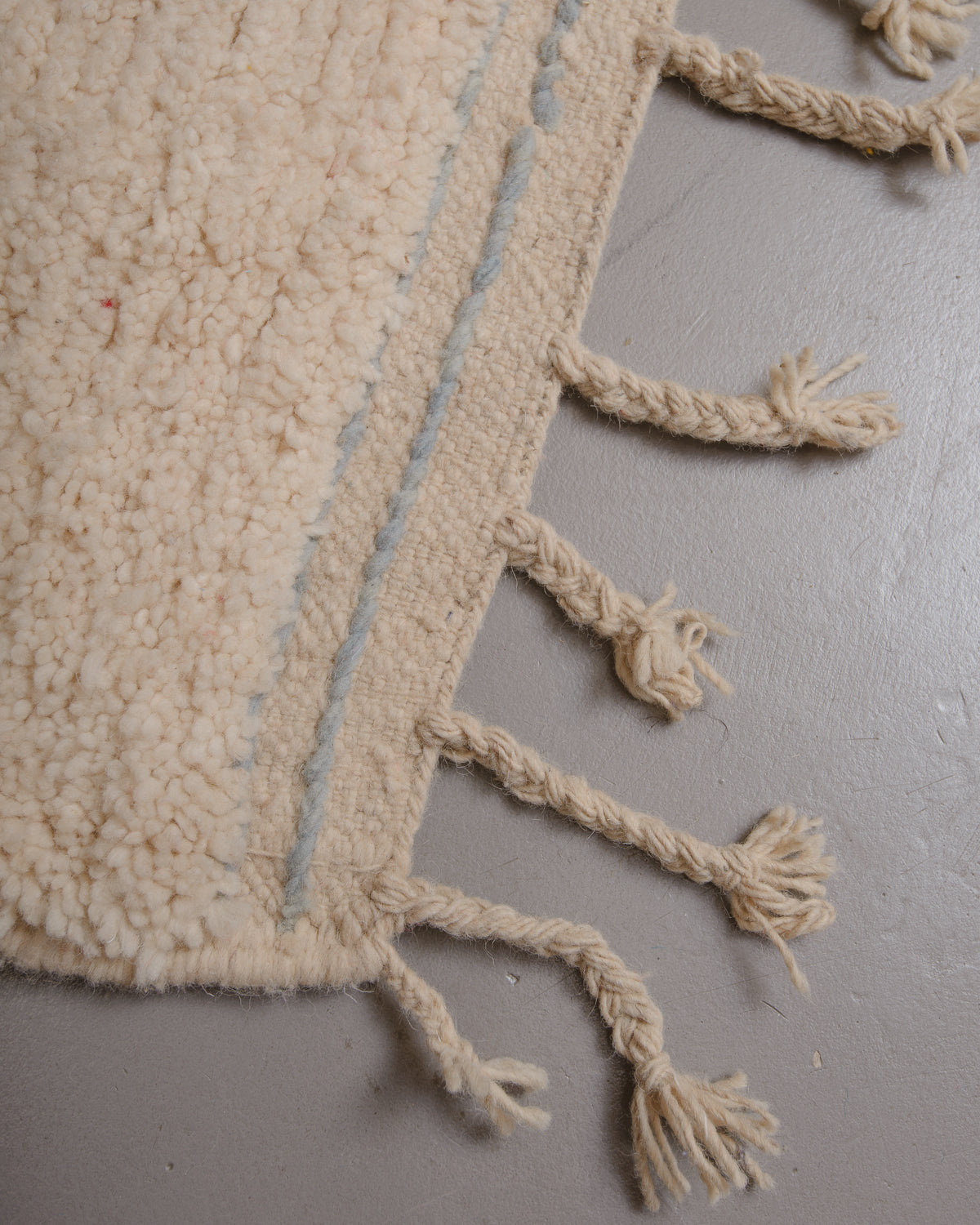 Corner of Berberlin rug with natural wool tassels along the edge.