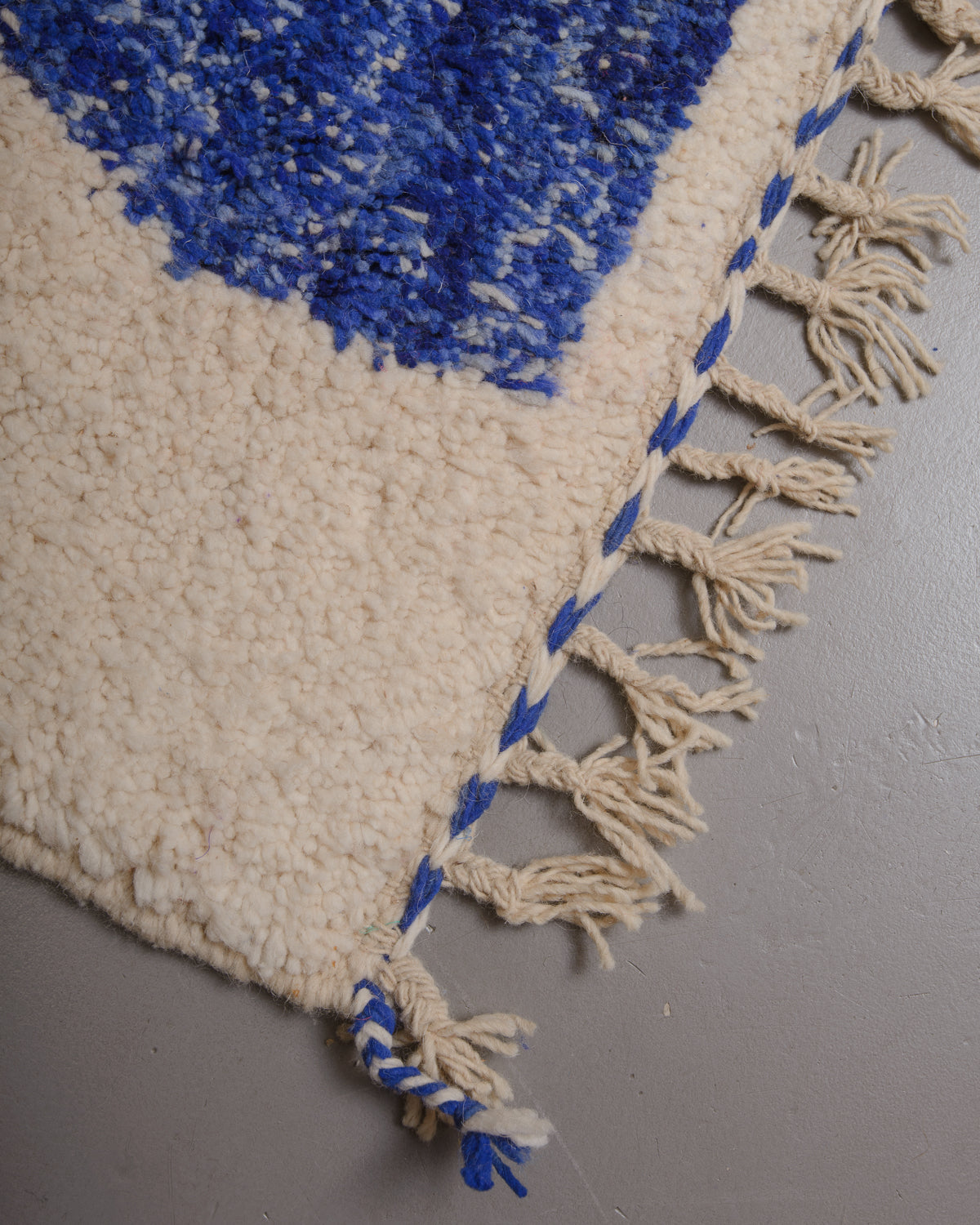 Corner of Berberlin rug with natural wool tassels along the edge.