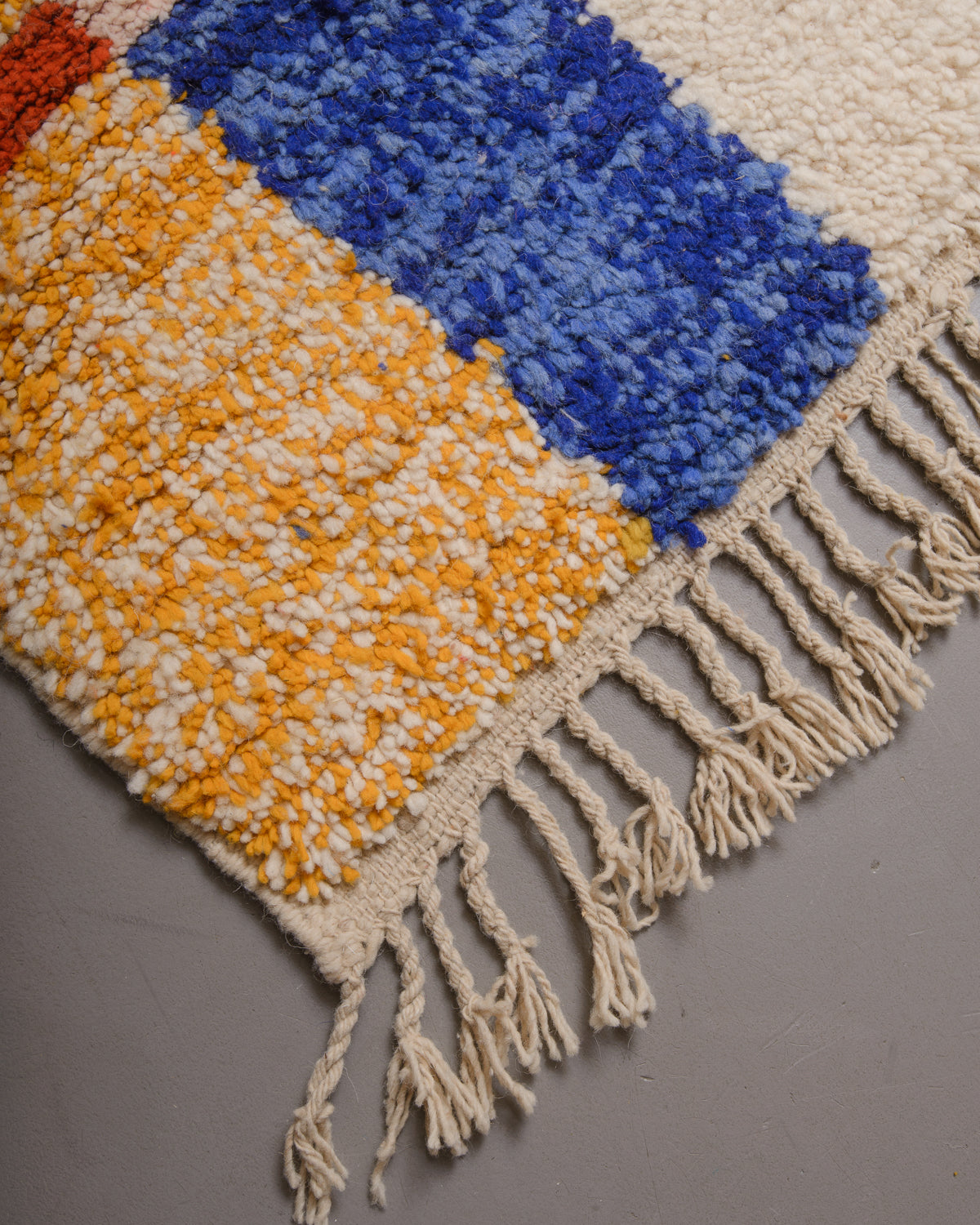 Corner of Berberlin rug with natural wool tassels along the edge.