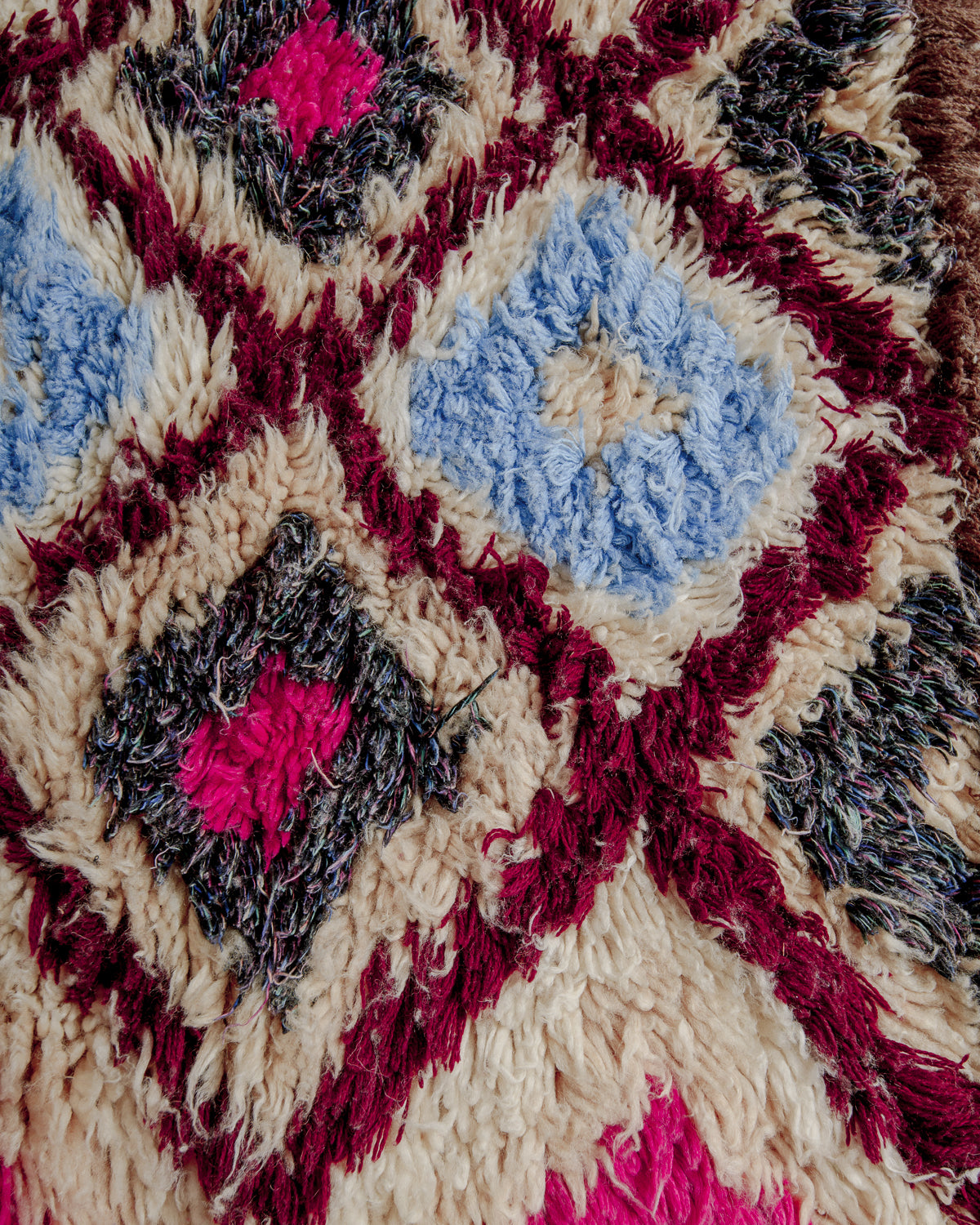 Close up of boucherouite rug surface with colourful cotton and cream wool.