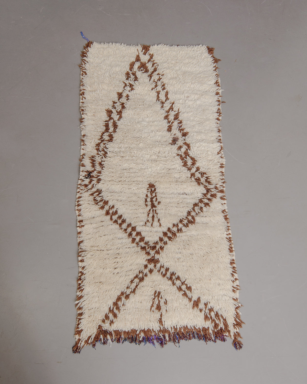Vintage Berberlin boucherouite runner rug on grey floor.