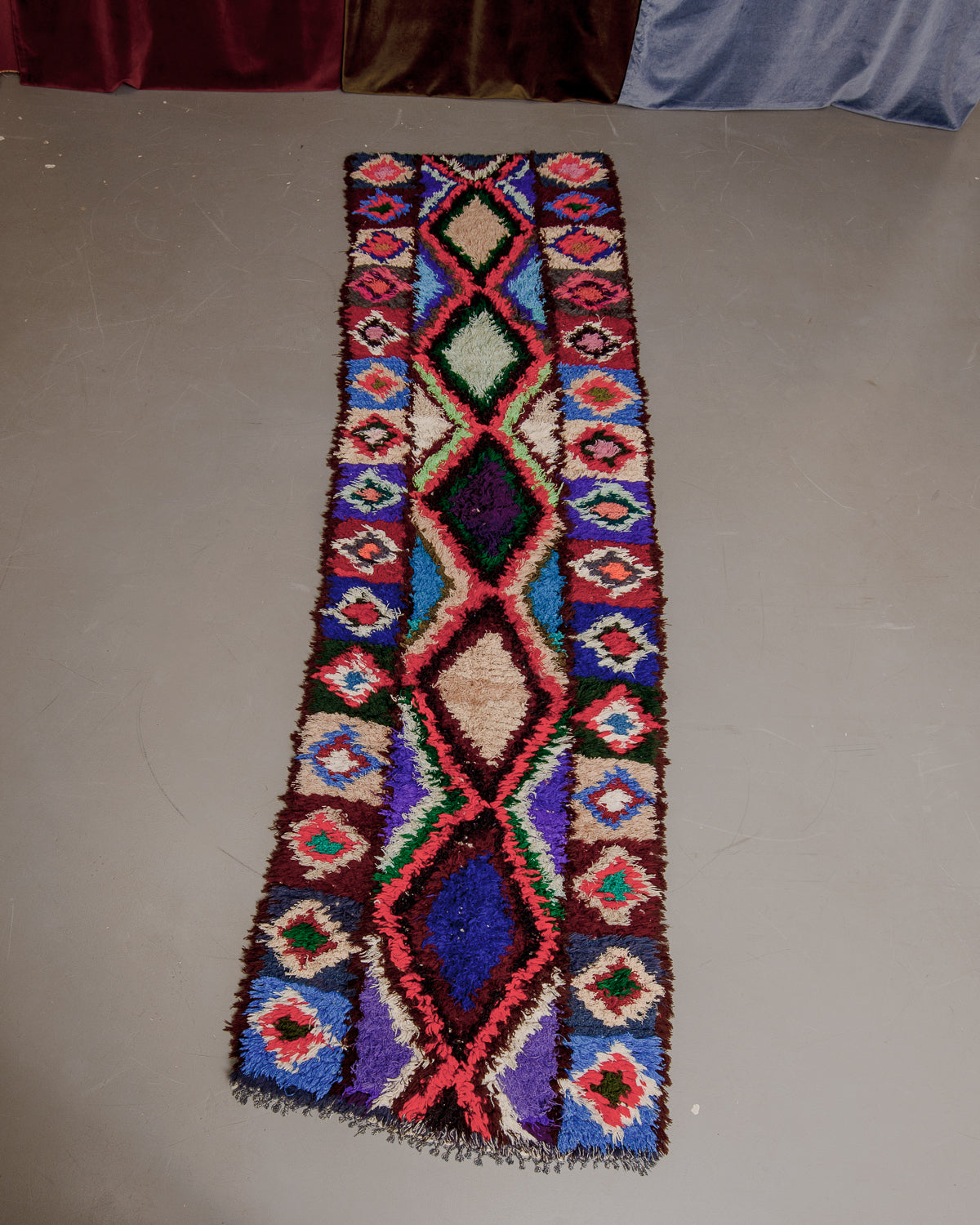 Vintage Berberlin boucherouite runner rug on grey floor.