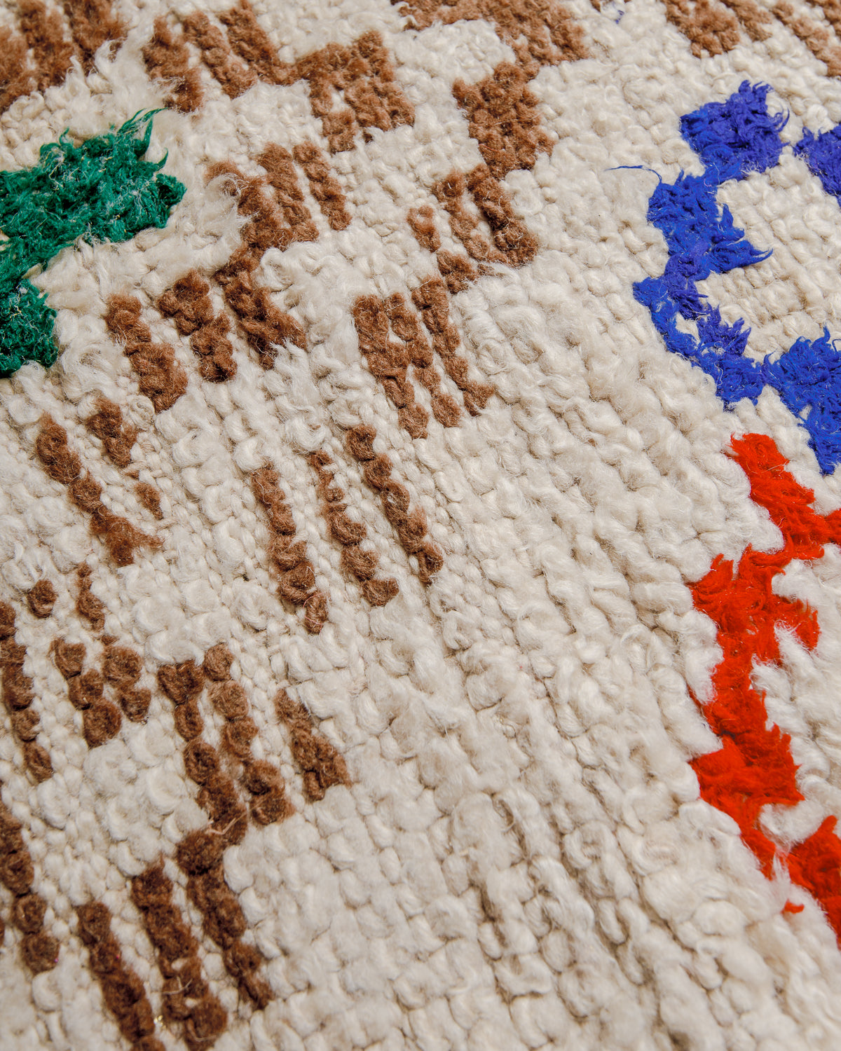 Close up of boucherouite rug surface with colourful cotton and cream wool.