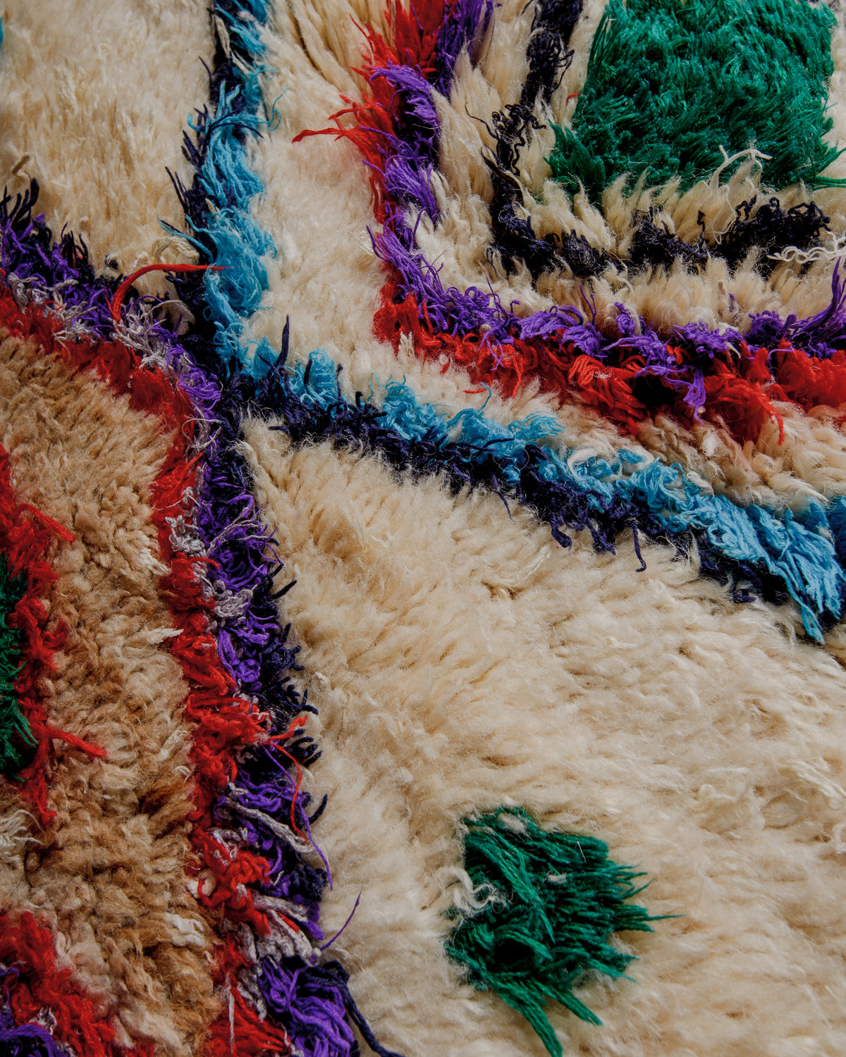 Close up of boucherouite rug surface with colourful cotton and cream wool.