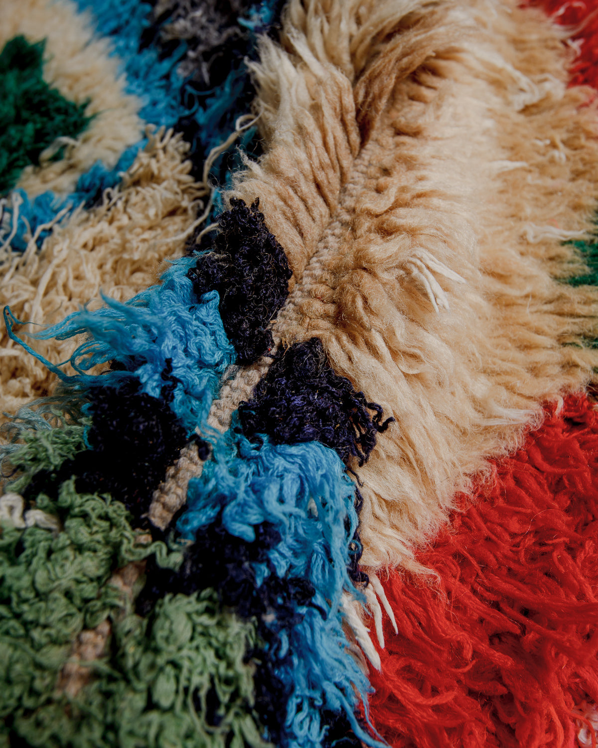 Close up of boucherouite rug surface with colourful cotton and beige wool.