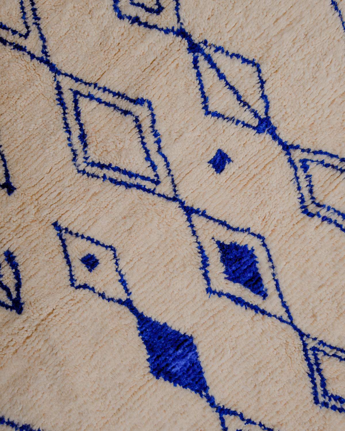 Surface of cream wool rug with symbols and motifs  in blue.
