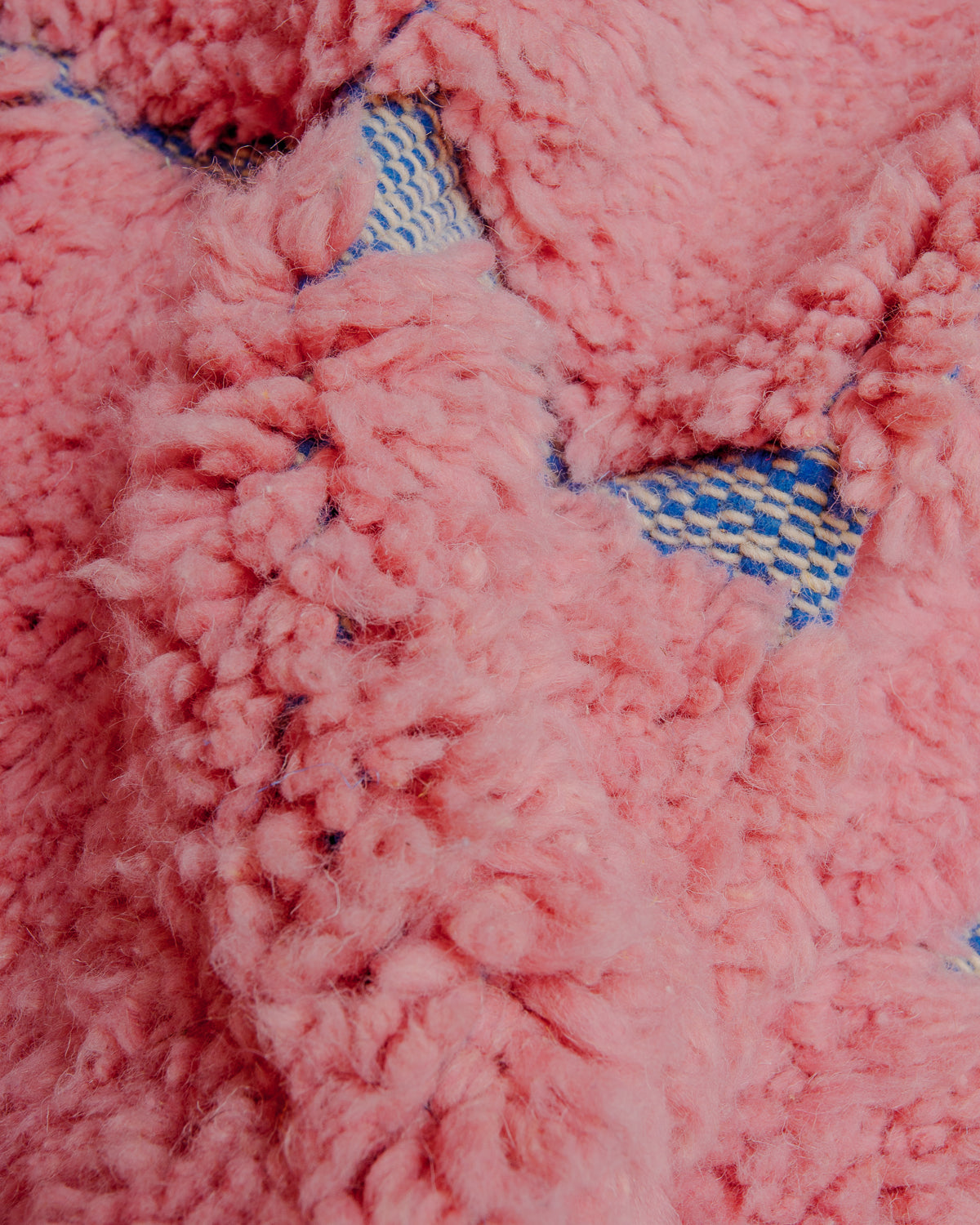 Fluffy pink wool and woven blue of beniourain rug.