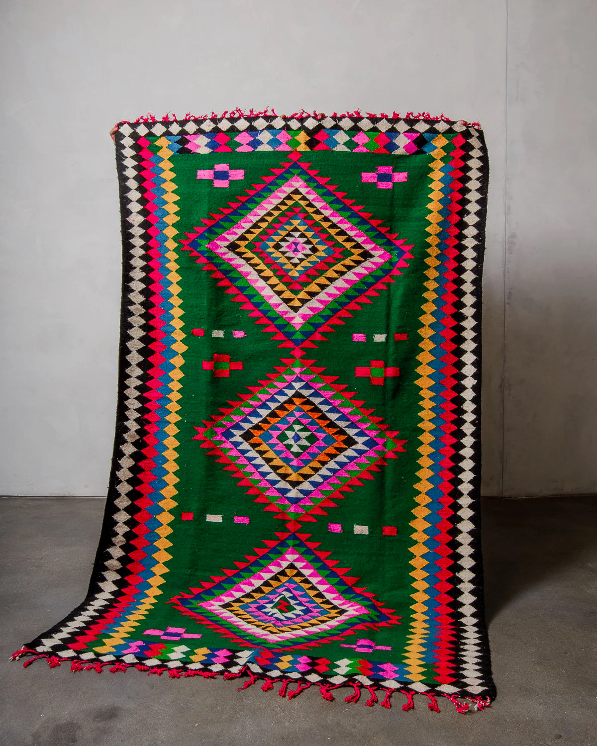 Colorful geometric patterned rug on a plain background