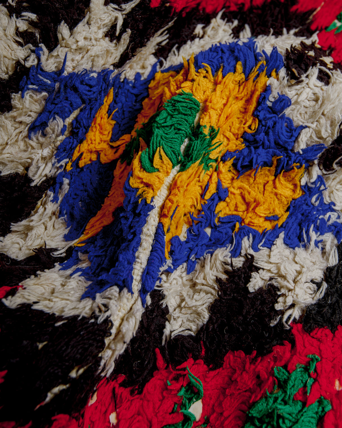 Close up of boucherouite rug surface with colourful cotton.