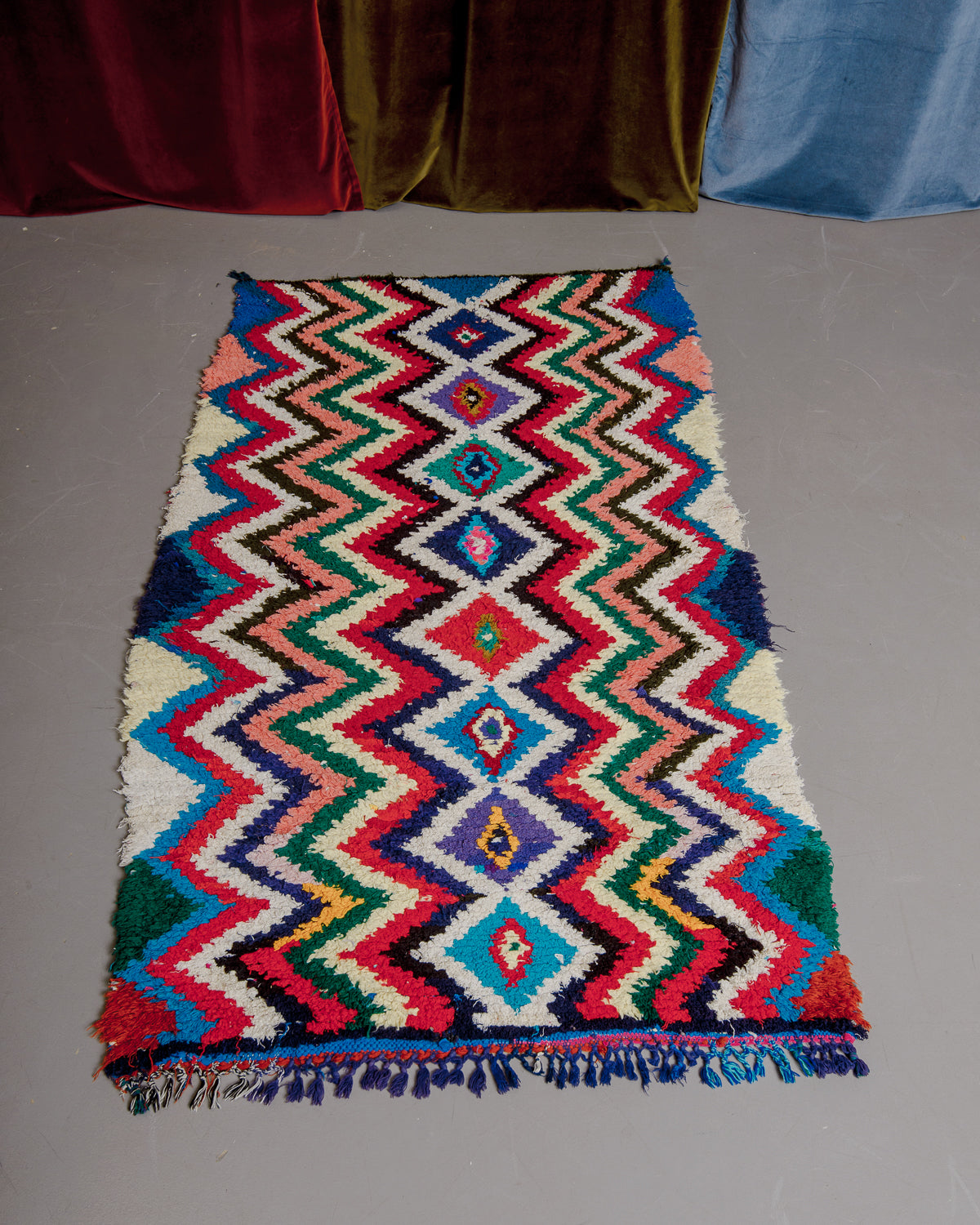 Vintage Berberlin boucherouite runner rug on grey floor.