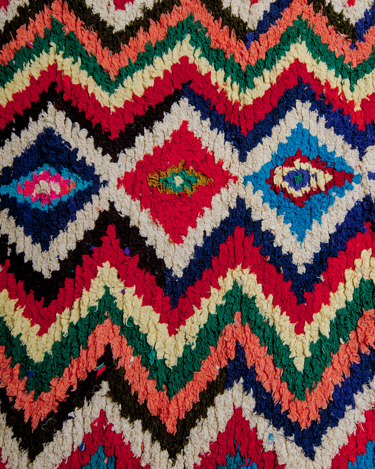 Close up of boucherouite rug surface with colourful cotton.