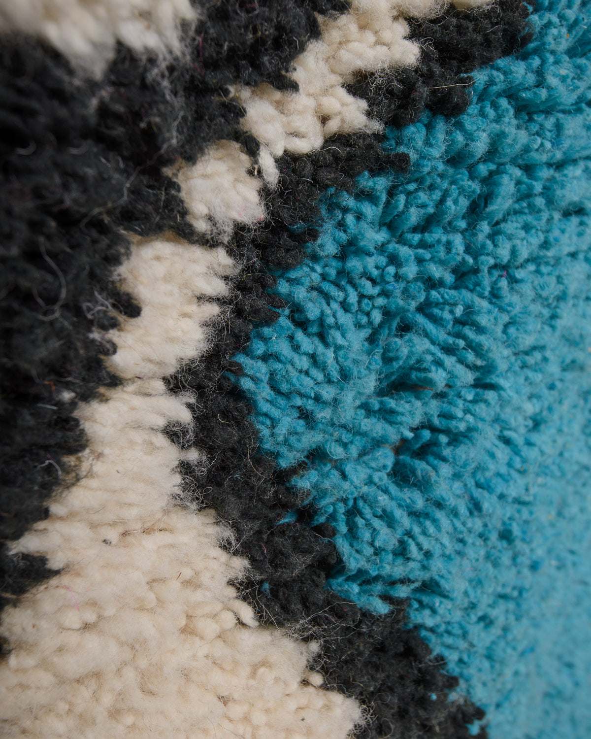 Close up of vintage boujaad rug showing the different shades of wool and surface texture.