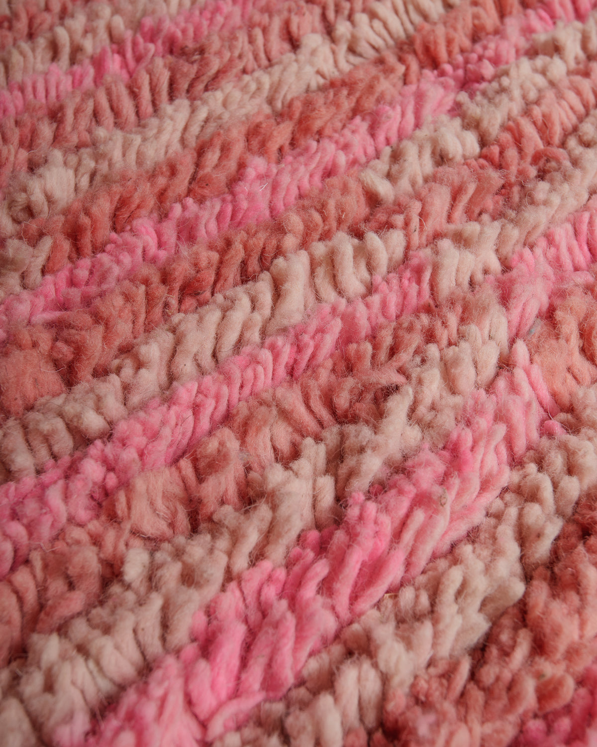 Close up of vintage boujaad rug showing texture and different shades of warm pink wool.