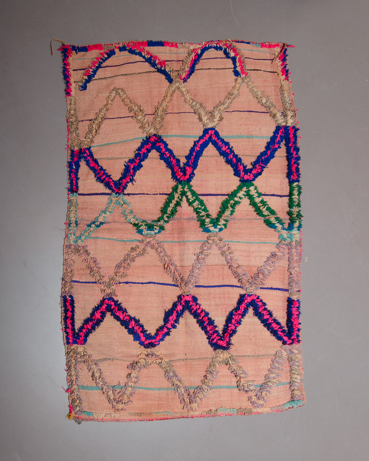 Vintage flat woven Kelim with fluffy embroidered pattern on grey floor.