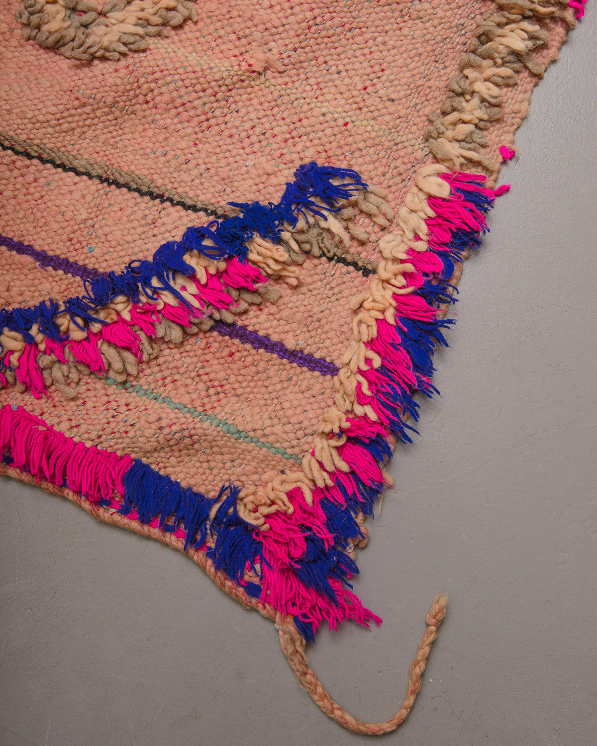 Corner of flat woven wool kelim rug with fluffy embroidered pattern.
