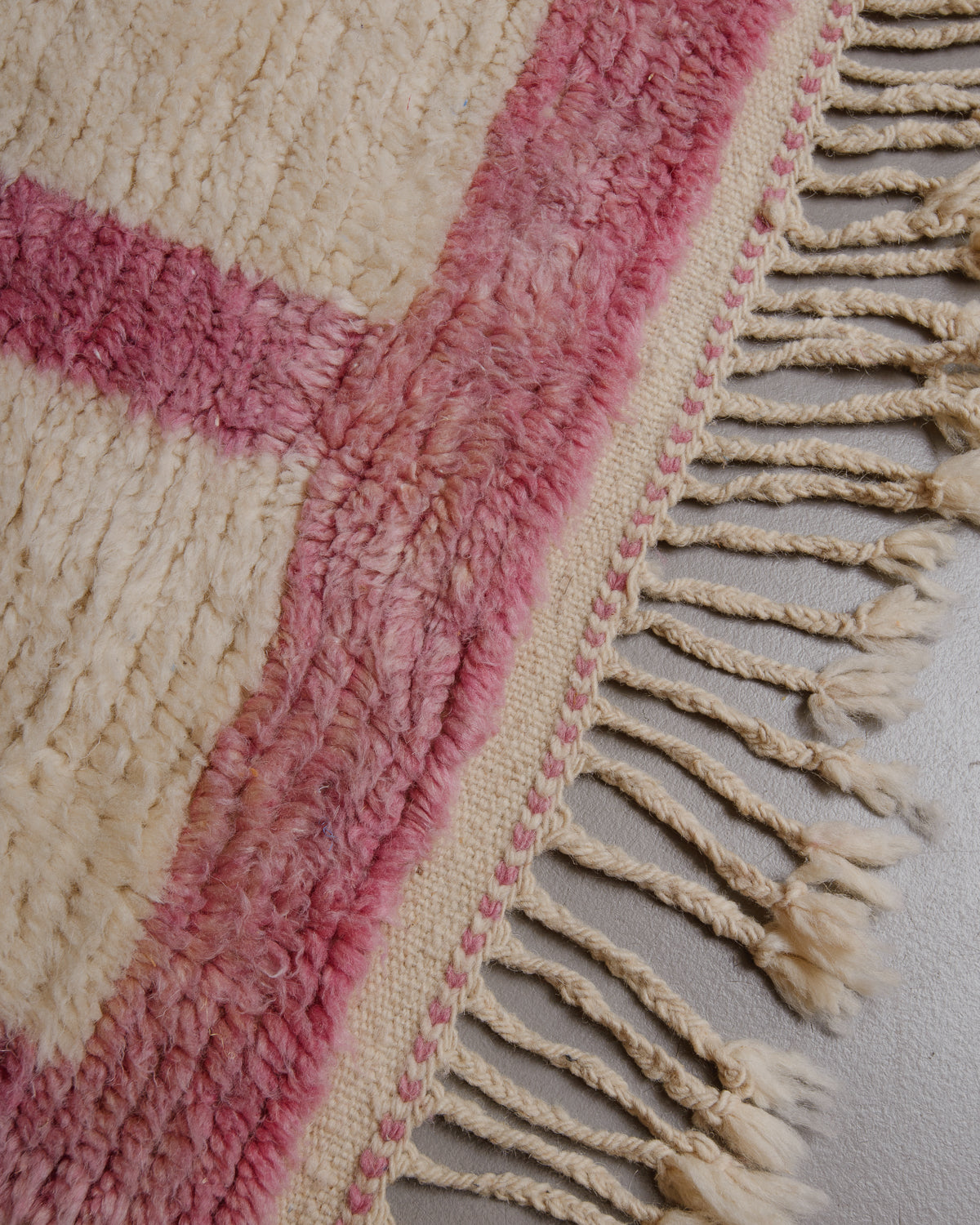 Corner of Berberlin azilal rug with natural wool tassels.