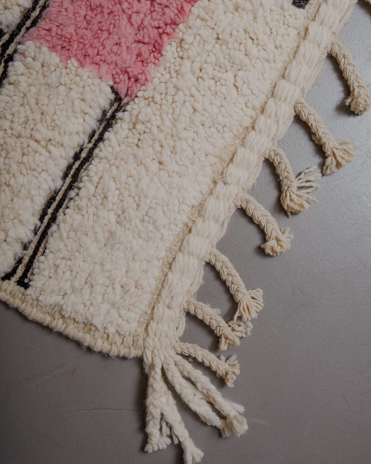 Edge of cream beniourain rug with natural wool tassels.