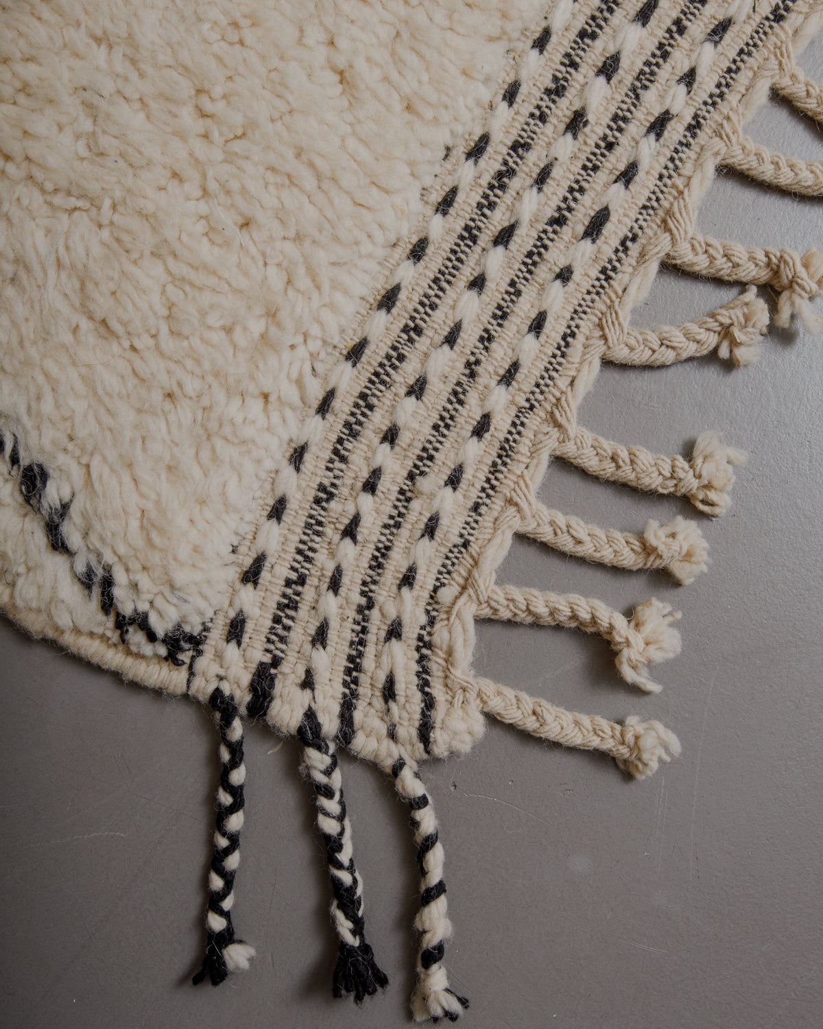 Edge of cream beniourain rug with natural wool tassels.
