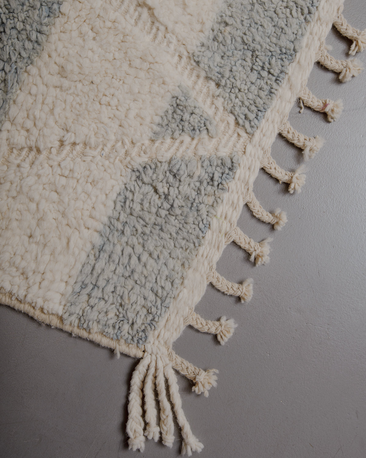 Edge of cream beniourain rug with natural wool tassels.