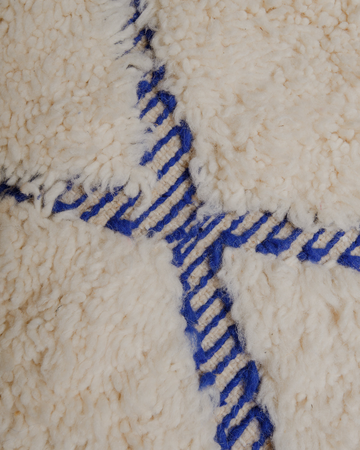 Close up of fluffy cream and blue wool rug. 