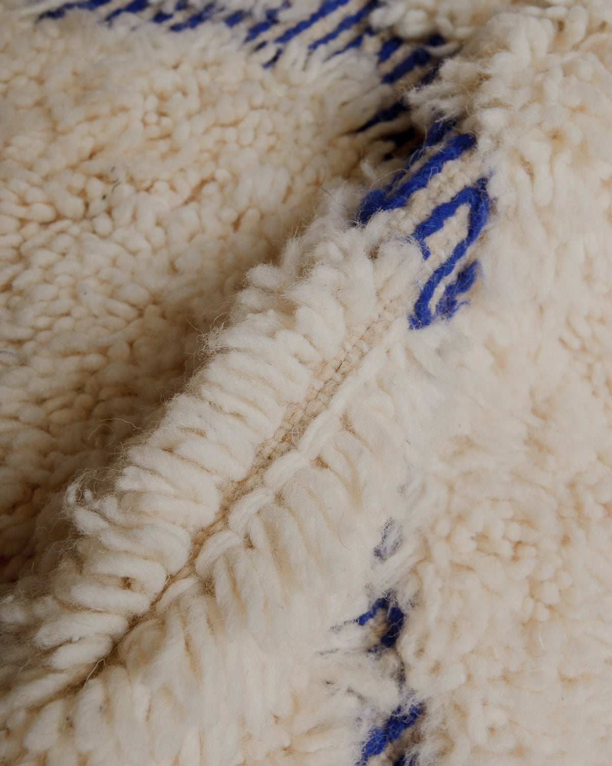 Close up of fluffy cream and blue wool rug. 
