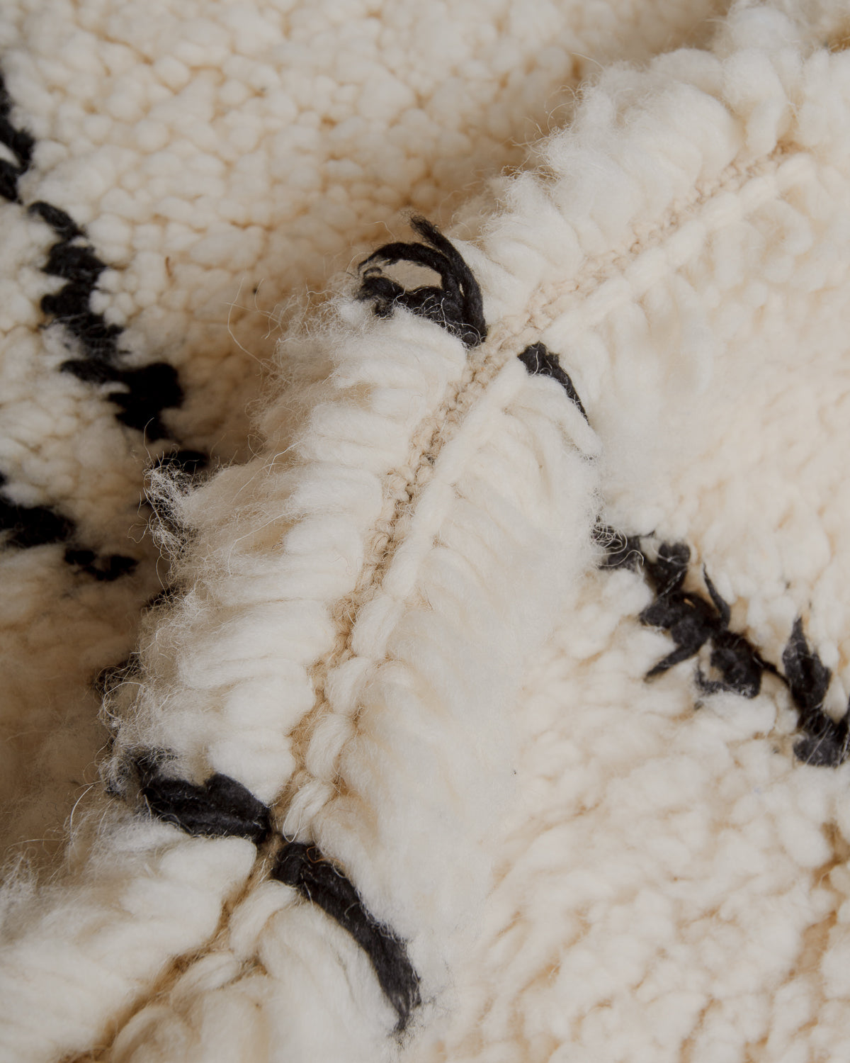 Close up of fluffy cream and black wool rug. 