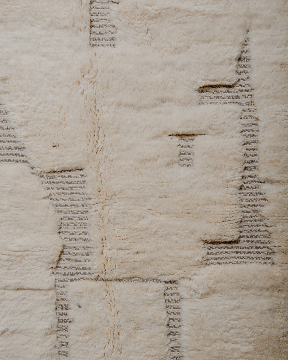 Fluffy cream wool pile with grey striped woven design.