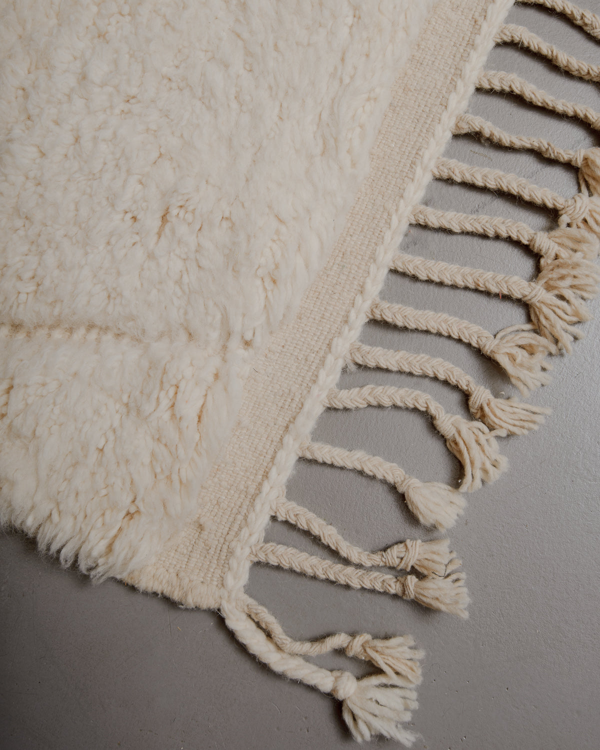 Edge of cream beniourain rug with natural wool tassels.