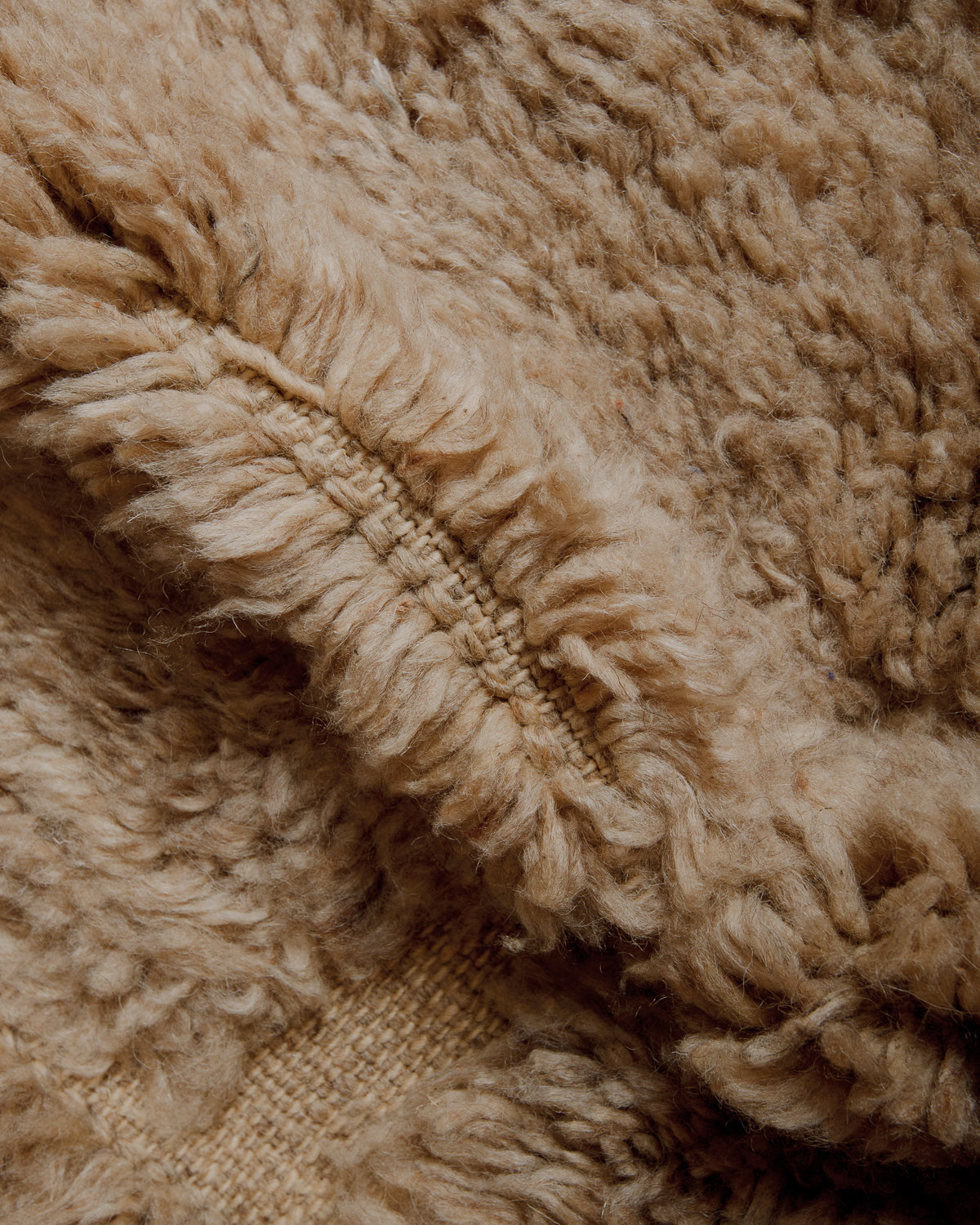 Fluffy brown wool with flat woven areas.