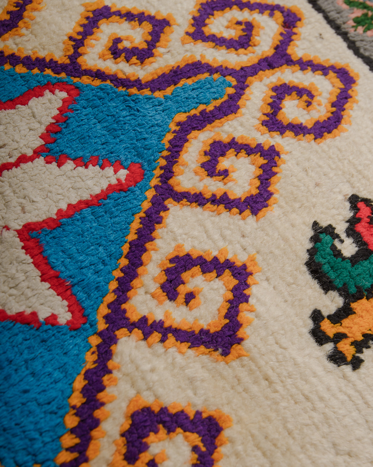 Surface of vintage rug made of cream wool and colourful cotton.
