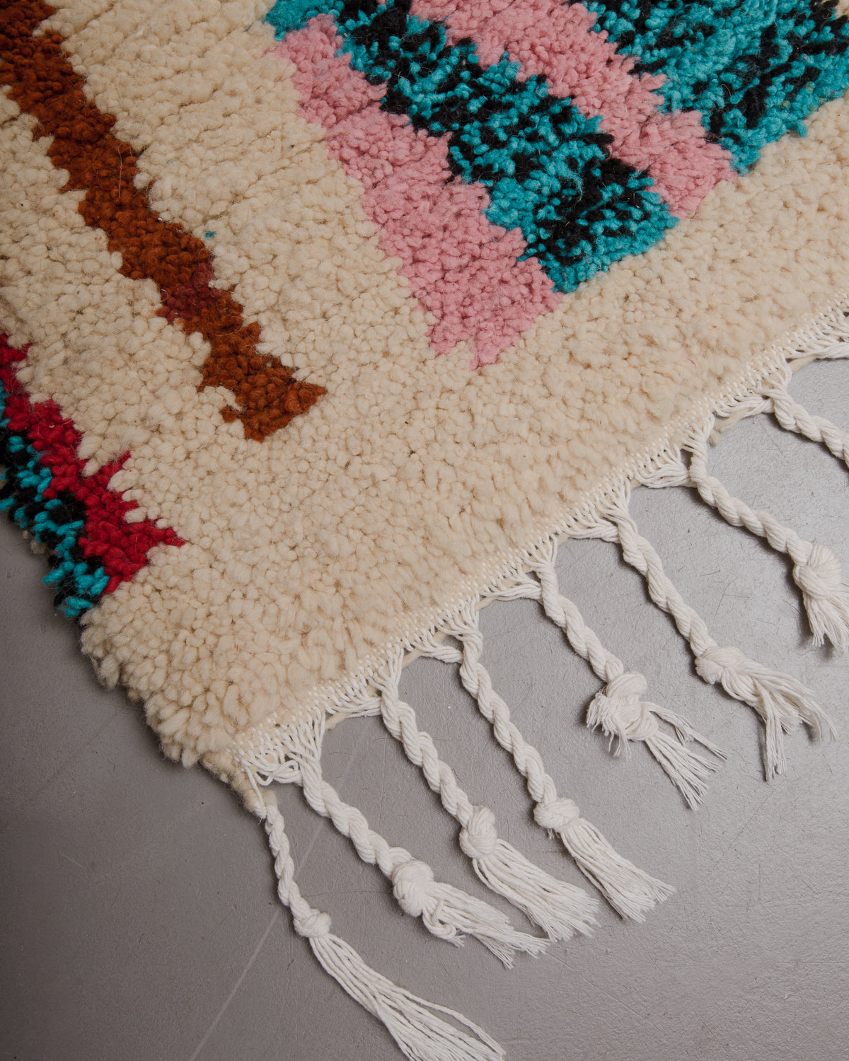 Edge of boujaad rug with white cotton tassels.