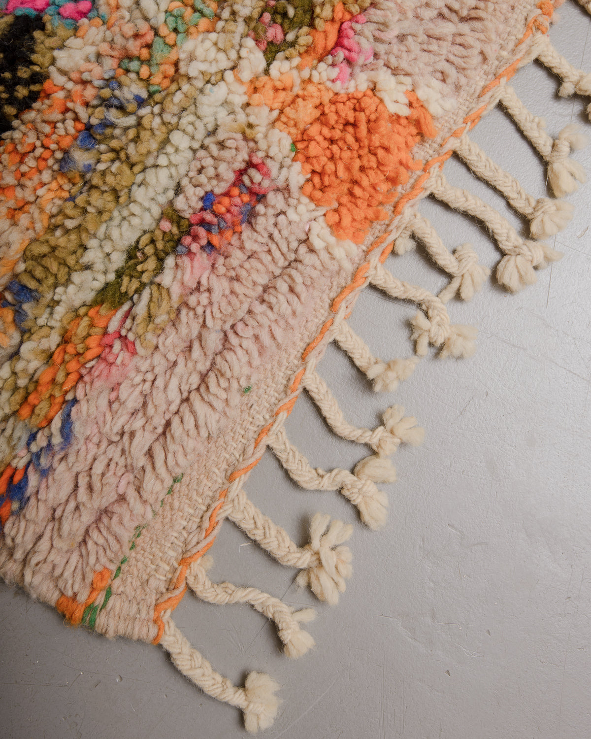 Edge of boujaad rug with wool tassels.