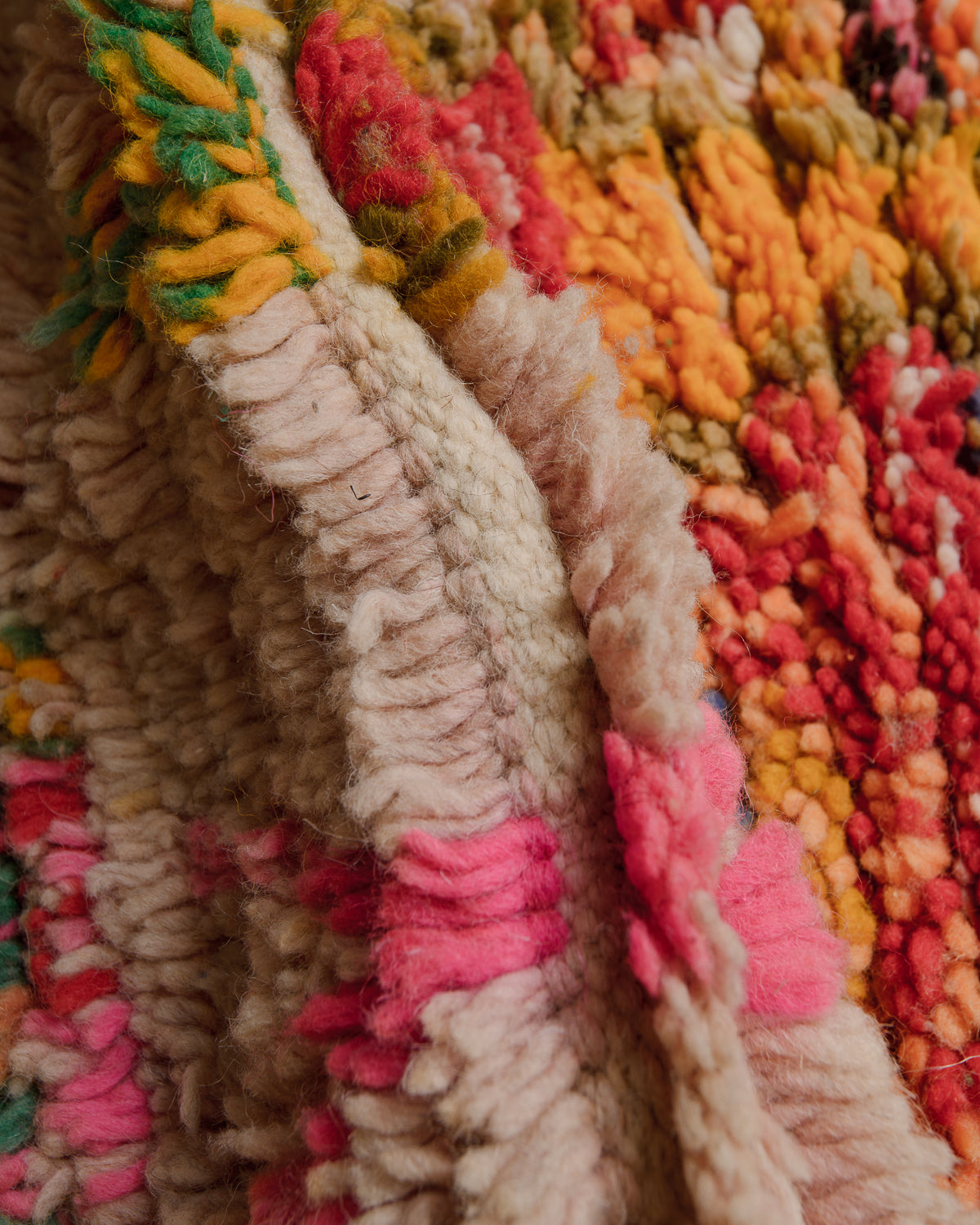 Close up of Boujaad rug with pink, rose, green,  red, orange and cream wool.