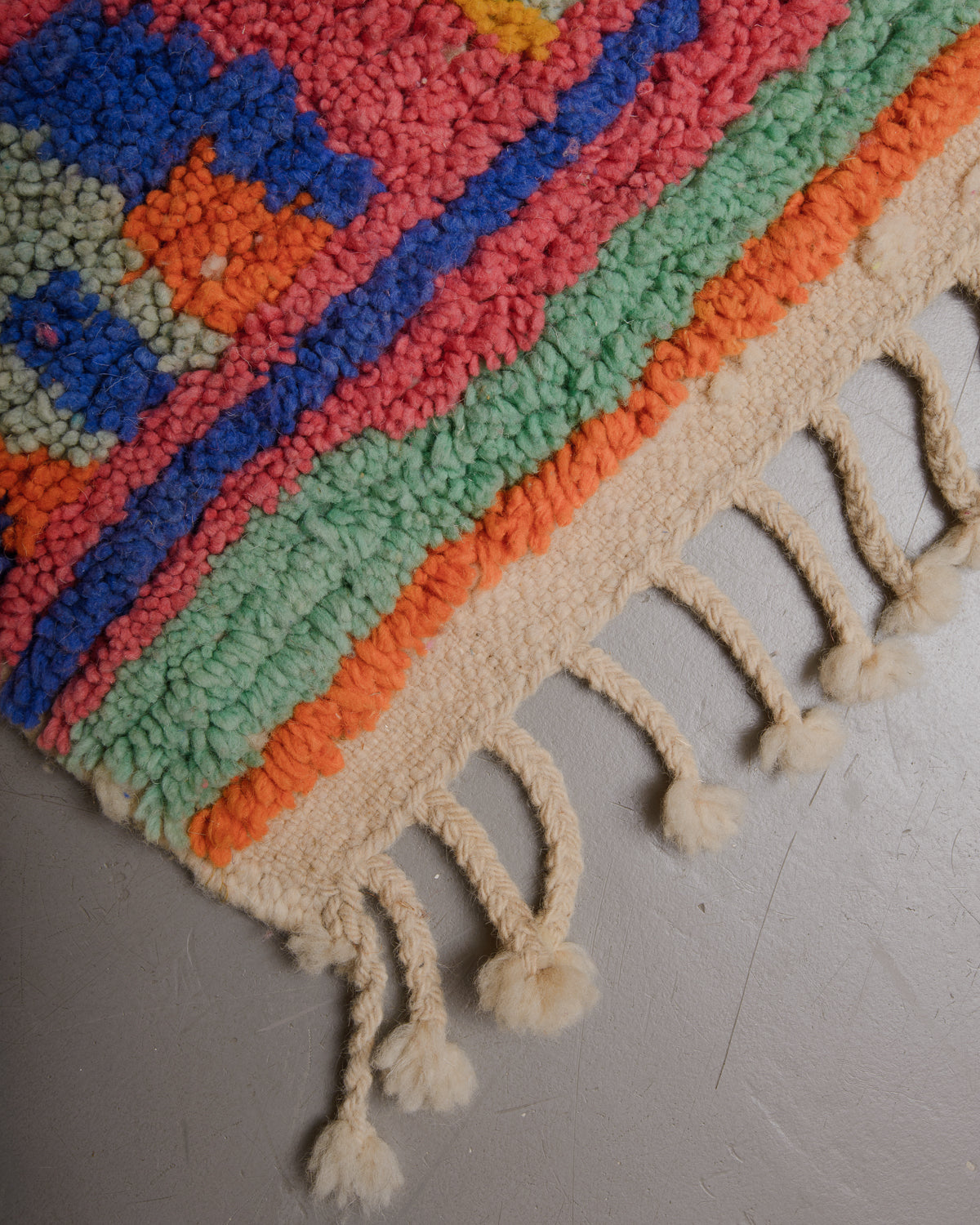 Edge of boujaad rug with wool tassels.