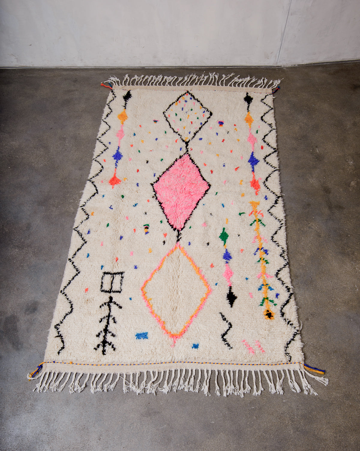 Berberlin Azilal rug made of fluffy wool and cotton, laying flat on a concrete floor. 