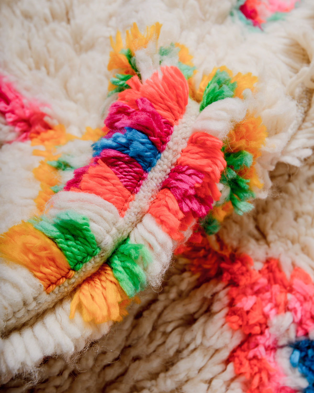Close-up of a fluffy Azilal rug, showcasing the intricate spacing of the rows, the dense wool pile texture and bright colours.