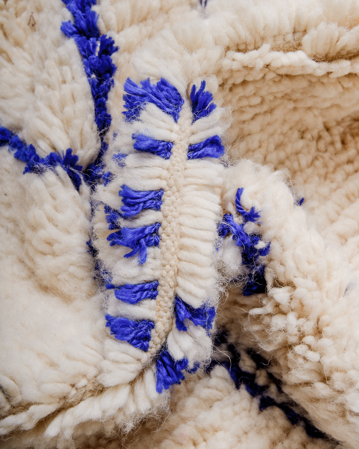 Close-up of a fluffy Azilal rug, showcasing the intricate spacing of the rows, the dense wool pile texture and bright colour.