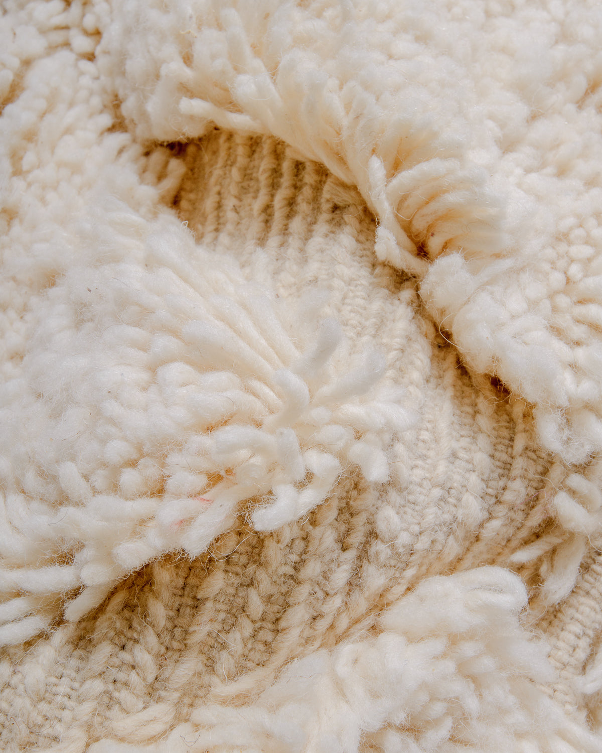 Detail of fluffy cream wool pile of Berber rug.